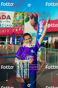 Participante de camiseta roxa sorrindo e levantando um braço em retrato dirigido